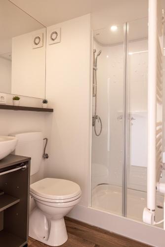 a white bathroom with a toilet and a shower at Safarizelt in Großenbrode