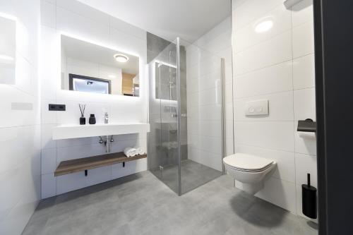 a white bathroom with a shower and a toilet at Wellnessappartement Winterberg D4 in Winterberg