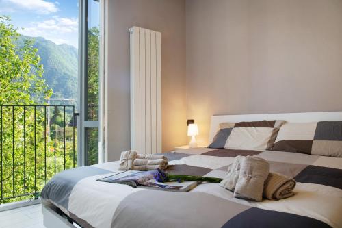 a bedroom with a large bed and a balcony at Il sole di calde Lago maggiore 504 in Castelveccana