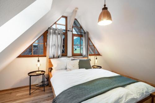 a bedroom with a bed and two windows at Schwarzwaldmomente in Hornberg