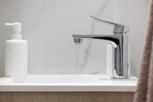a bathroom sink with a faucet with water coming out at Família Dória Nóbrega T0 in Funchal