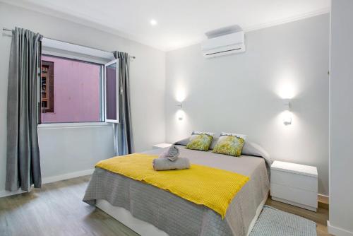 a bedroom with a bed with a yellow blanket at Família Dória Nóbrega T0 in Funchal