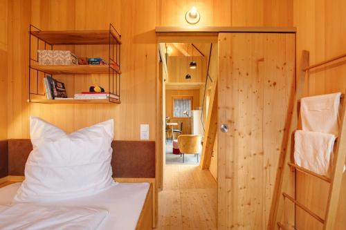 a bedroom with a bed and a wooden wall at Tinyhaus am Bussen in Unlingen