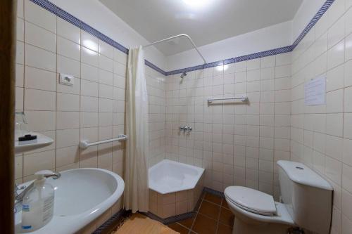 a bathroom with a toilet and a tub and a sink at Casa de Valdemar in Felgueiras