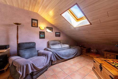 a bedroom with a bed and a chair in a attic at Gîte le Chamoyard in Chamoux-sur-Gelon