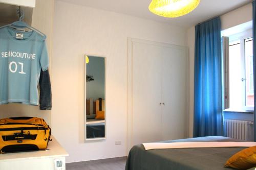 a bedroom with a bed and a mirror and a suitcase at Vichi's nest in Pianello Del Lario