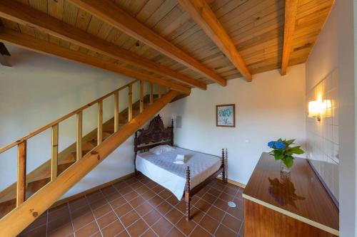 a room with a staircase with a bed and a table at Casa de Valdemar in Felgueiras