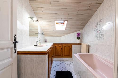 a white bathroom with a tub and a sink at Gîte le Chamoyard in Chamoux-sur-Gelon