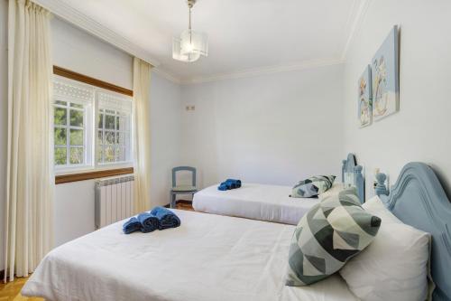 a bedroom with two beds and a window at Casa Dona Lola in Moledo