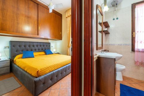 a bedroom with a bed and a bathroom with a sink at Appartamento Pinus in Santa Margherita di Pula