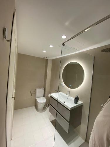 a bathroom with a toilet and a sink and a mirror at Ca la Montse in Altafulla
