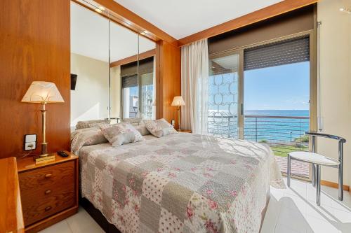 a bedroom with a bed and a large window at Ca la Montse in Altafulla
