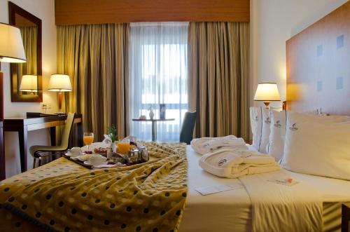 a hotel room with a bed with towels on it at VIP Executive Santa Iria Hotel in Santa Iria da Azóia