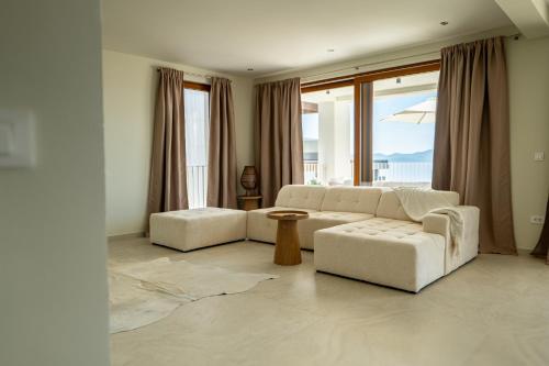 a living room with two white couches and a table at Kožino Bay Lodge - Brand New Seaside Apartments, Heated Pool in Kožino