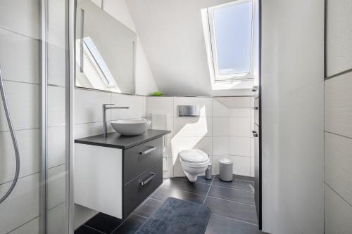 a bathroom with a sink and a toilet and a window at Ferienwohnung Luna in Bindlach
