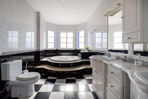 a bathroom with two sinks and a toilet and a tub at Milestone House in Rincón de la Victoria