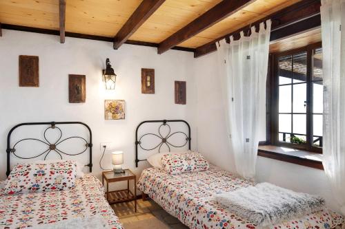 a bedroom with two beds and a window at Media Pipa in Puntagorda