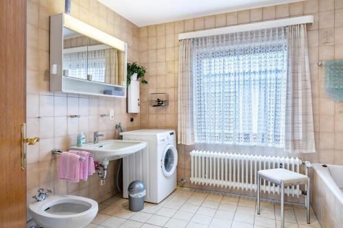 a bathroom with a washing machine and a sink at Haus Lahrsen in Wesselburen
