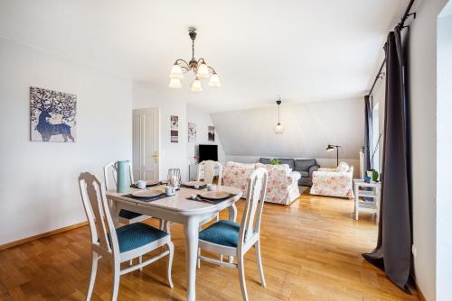 a dining room and living room with a table and chairs at Ferienwohnung Gestüt Kriseby in Lübeck