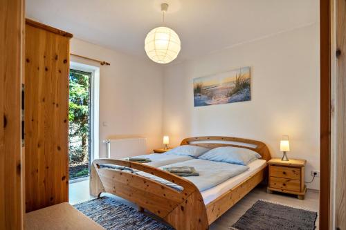 a bedroom with a large wooden bed with blue pillows at Hof Verchen Nahe Kummerower See in Verchen