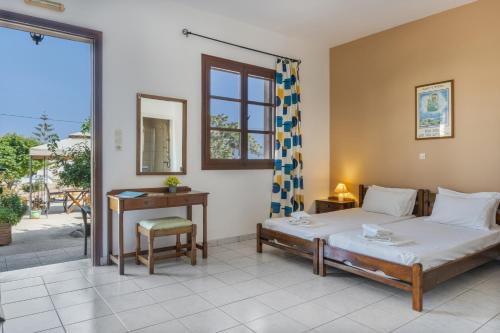 a bedroom with a bed and a table and a mirror at Frantzis studio 3 Nisyros in Páloi