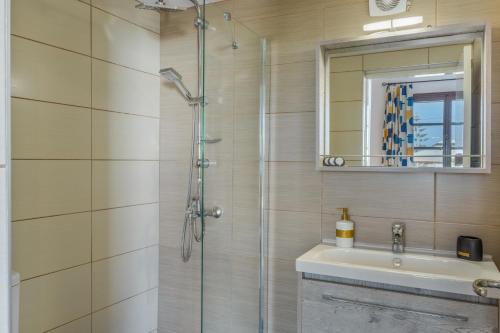 a bathroom with a shower and a sink and a mirror at Frantzis studio 3 Nisyros in Páloi