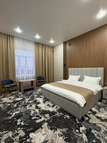 a bedroom with a large bed and a large rug at Essenali in Taraz