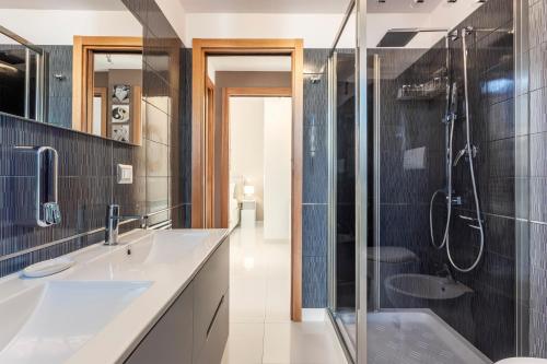 a bathroom with two sinks and a shower at Olimar Home in Santa Flavia
