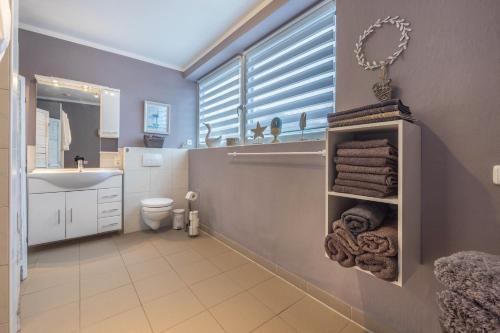 a bathroom with a sink and a toilet and a mirror at Haus Erika in Brunsbüttel