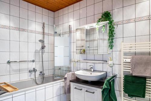 a bathroom with a sink and a tub and a mirror at Ferienwohnung Bernoth in Erfurt