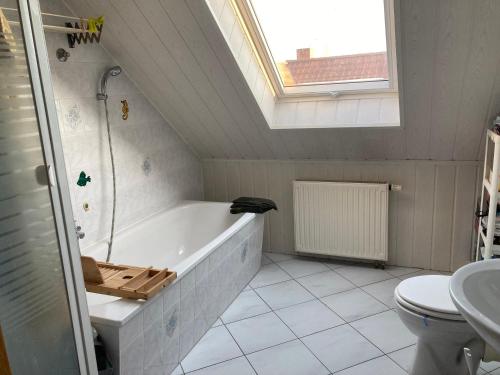 a bathroom with a bath tub and a toilet at Ferienwohnung Wie zu Hause in Ostritz