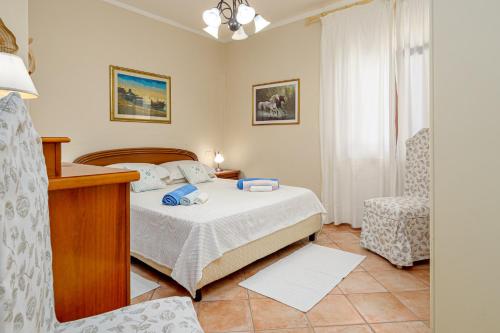 a bedroom with a bed and a chair at Casa Anna in San Teodoro