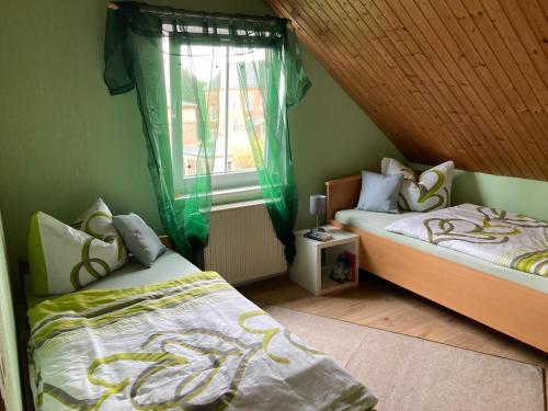 a bedroom with two beds and a window at Ferienwohnung Wie zu Hause in Ostritz
