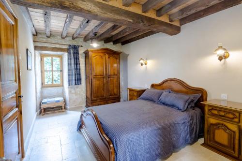 a bedroom with a bed in a room with wooden ceilings at Chez Jacquou in Bouniagues