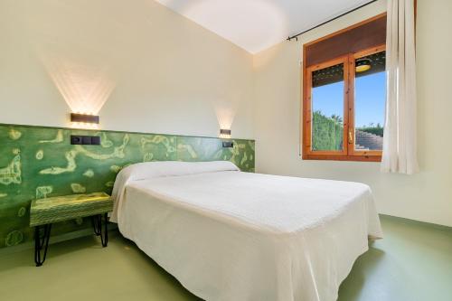 ein Schlafzimmer mit einem weißen Bett und einem Fenster in der Unterkunft Carpa in Riumar