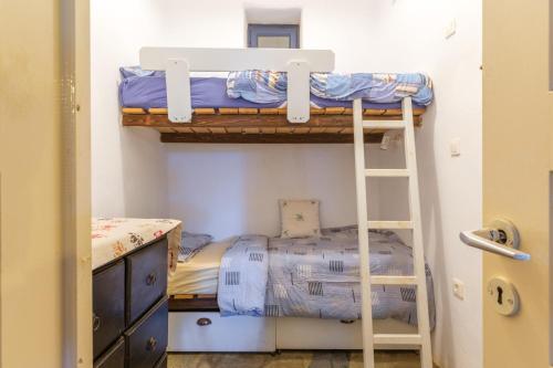 a bedroom with two bunk beds and a ladder at Kykladen White House in Koumáros