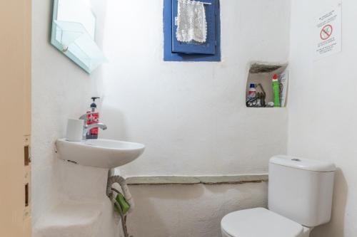 a bathroom with a white toilet and a sink at Kykladen White House in Koumáros