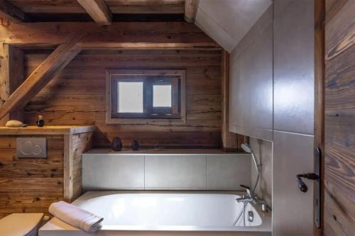 a bath tub in a room with a window at Mazot des aravis in Combloux