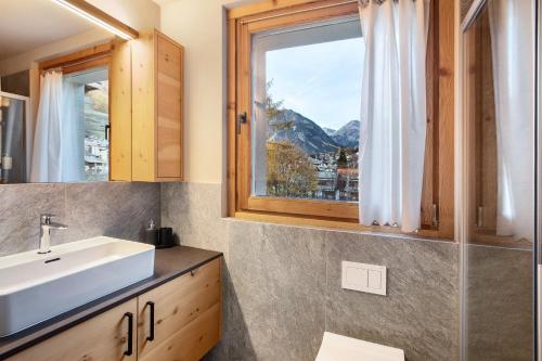 ein Badezimmer mit Waschbecken und Fenster in der Unterkunft Quattropassi Bormio in Bormio