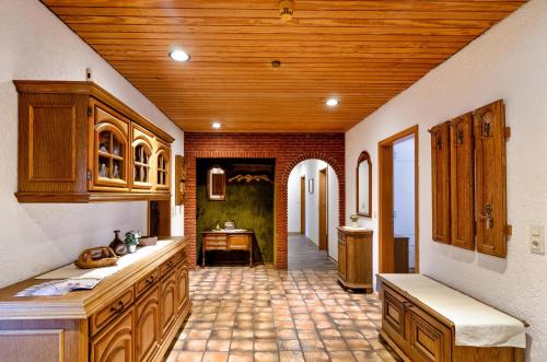 a kitchen with wooden cabinets and a tile floor at Haus Störtebeker in Marienhafe