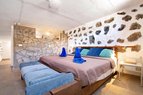 a bedroom with a large bed with blue pillows at Alma Eco-rústico Adults Only in El Charco