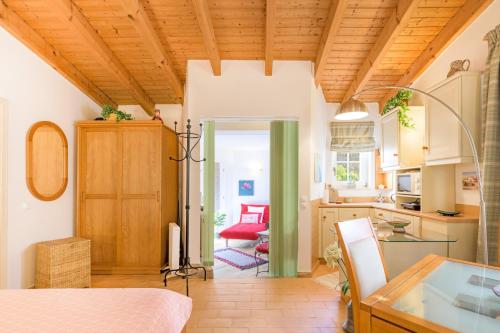 a room with a bed and a table and a kitchen at Casa Cisne - Selão da Eira in São Miguel