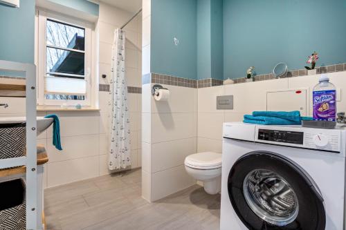 a bathroom with a toilet and a washing machine at Ferienwohnung - Wolkow in Wolkow