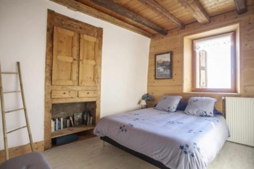 a bedroom with a bed with a ladder and a window at L'échappée des Rêves in Verchaix