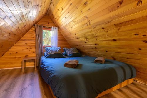 a bedroom in a log cabin with a bed in it at Chalet in Mittlach