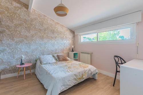 a bedroom with a bed and a table and a window at Villa Saint-Martin - Pompignac in Pompignac