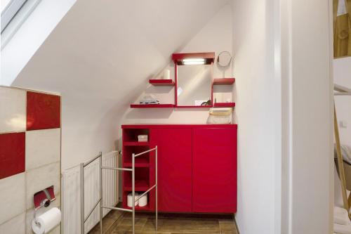 a bathroom with red cabinets and a red mirror at Alte Revierförsterei in Börfink