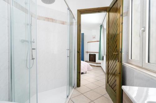 a bathroom with a shower and a glass door at La vela gialla in Cala Liberotto