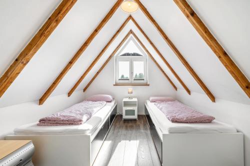 a attic bedroom with two beds and a window at Ferienwohnung Bayerl in Kirchseeon
