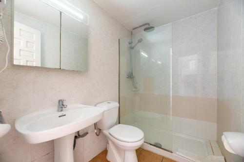 a bathroom with a toilet and a sink and a shower at Apartamento Isla Blanca in Es Pujols
